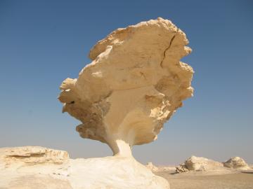 Large rock balanced on a narrow stem in the white desert